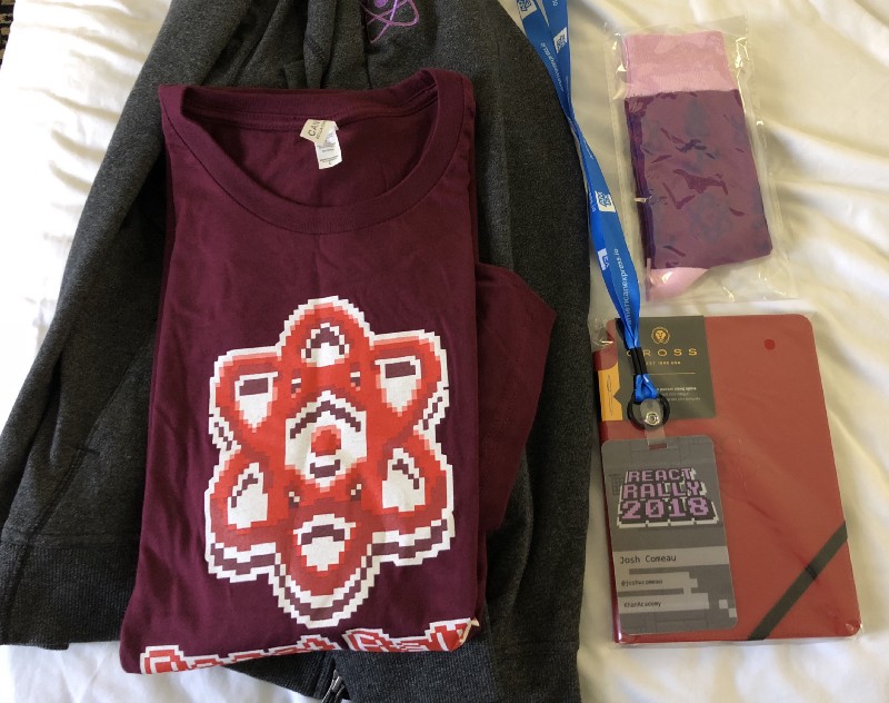 A set of swag including a T-shirt, a hoodie, socks, and a personalized notebook